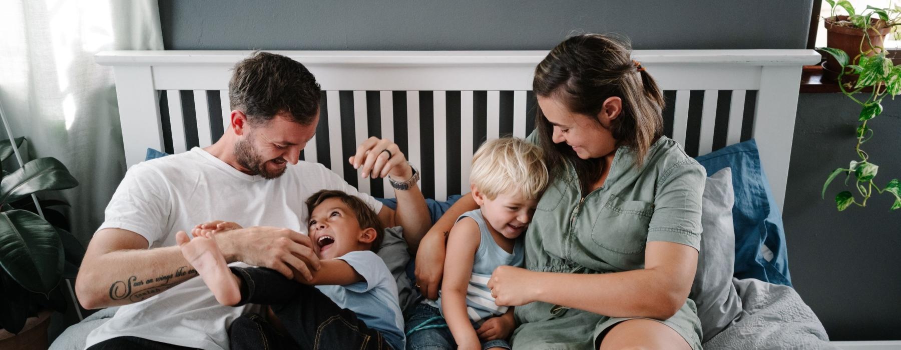 a family sitting on a bed