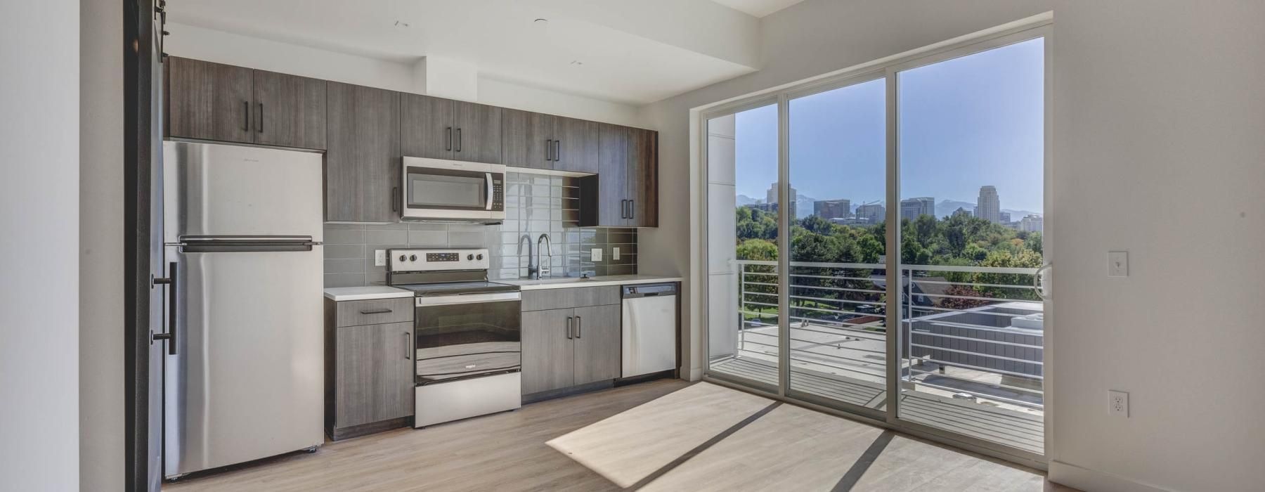 a kitchen with a large glass door to private balcony